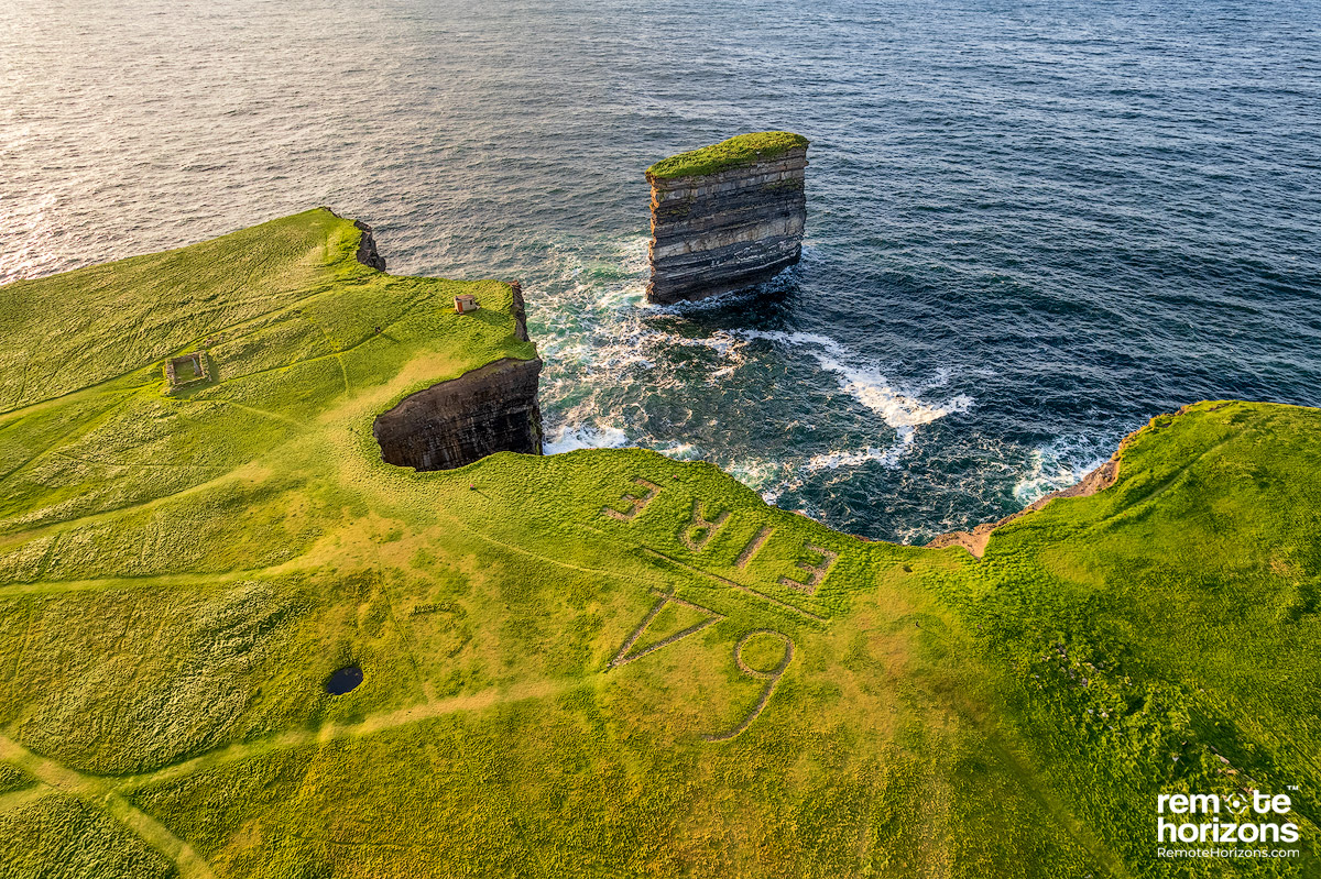 Aerial landscape photography of Downpatrick Head, County Mayo, Ireland.  This shows the Eire 64 sign from above along with the Dun Briste seat -stack in the background.