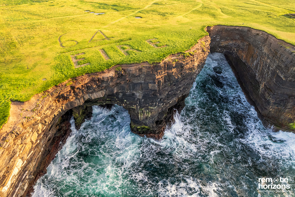 Aerial landscape photography of Downpatrick Head, County Mayo, Ireland.  This shows the Eire 64 sign from above and the sea cliffs.